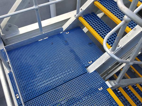 Blue FRP grating with yellow nosing is installed on the stairs.