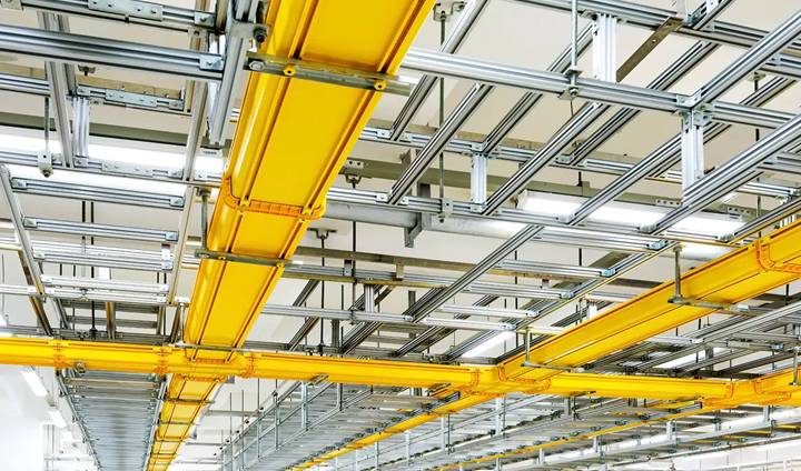 Des plateaux de câbles en fibre de verre jaune sont installés sur le toit pour le système de câblage.