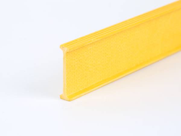 Une poutre jaune FRP/GRP avec surface de bride ondulée.