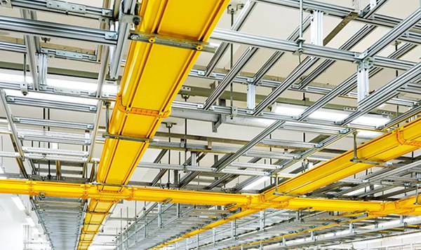 Yellow FRP/GRP cable trays are installed on the roof of building.