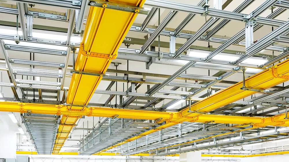Yellow FRP/GRP cable trays are installed on the roof of building.