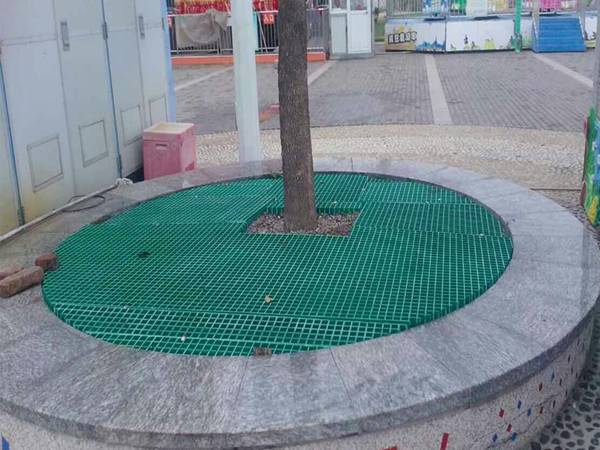 A green round guard is covering the tree well.