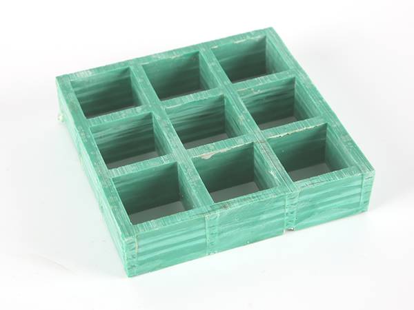 A piece of green color molded FRP/GRP grating with standard square meshes.