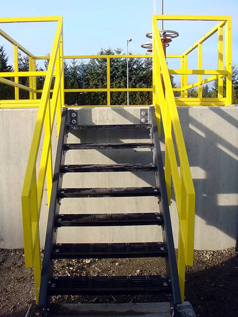 A yellow FRP/GRP handrail with stair treads.